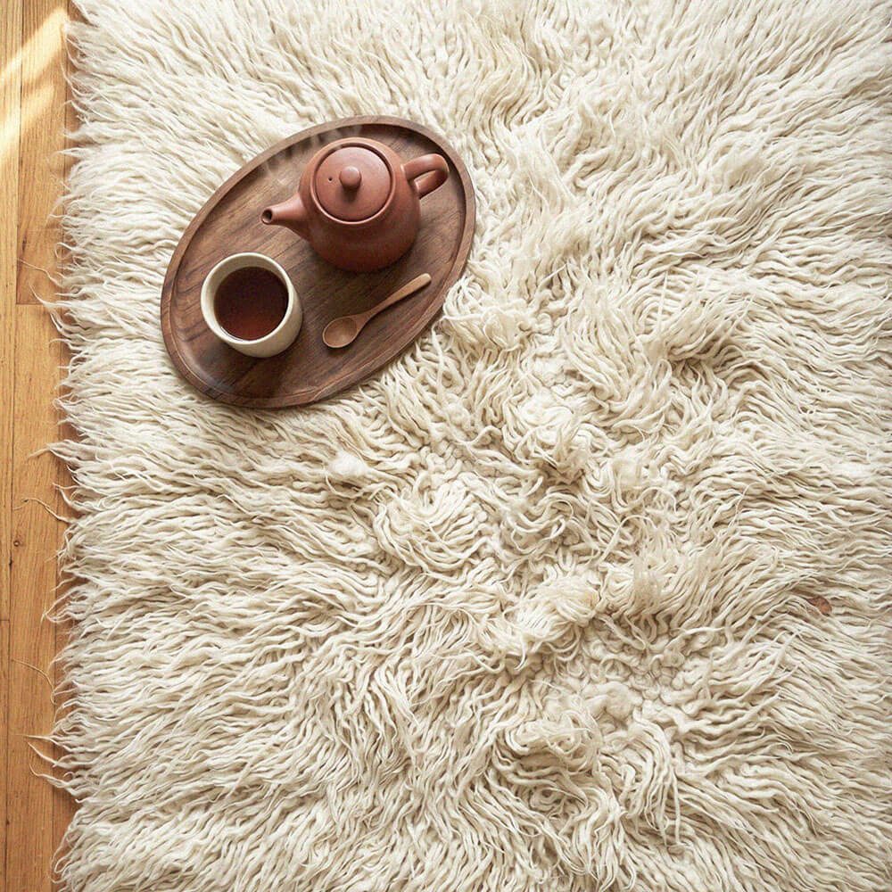 Tea set on a wooden tray on a fluffy white rug