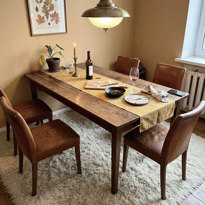 Dining room with wooden table and chairs, set for a meal and flokati shag rug on the floor