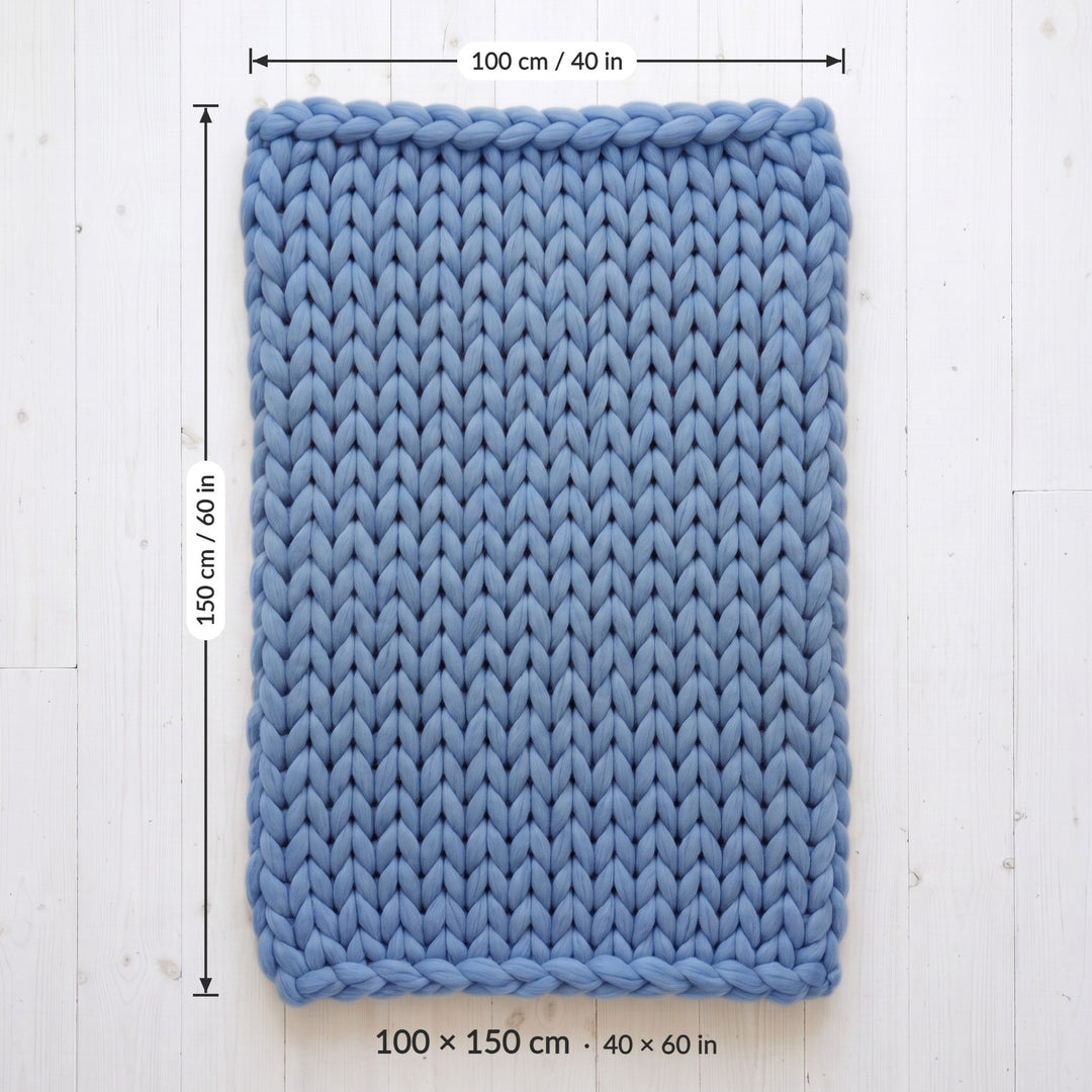 Chunky knit throw blanket size 100 x 150 cm (40 x 60 in), laid flat on a white wooden floor