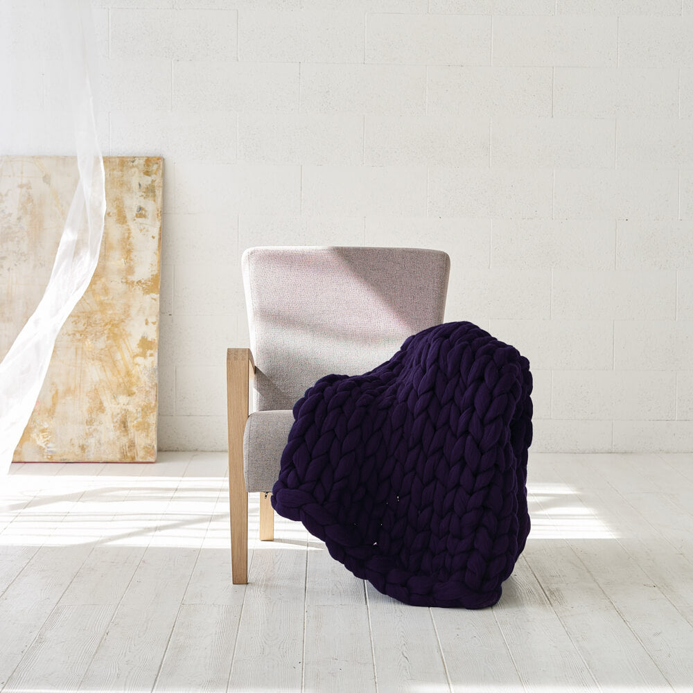 deep purple giant stitch blanket on the chair in a light room