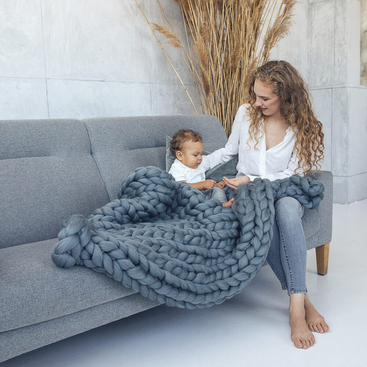 lady and her son sitting on the couch covered with grey chunky knit blanket 45X60 inches