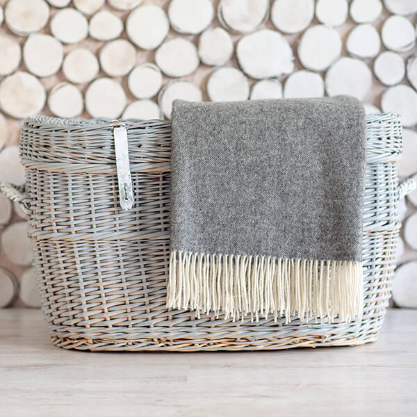 light grey merino wool blanket folded in basket