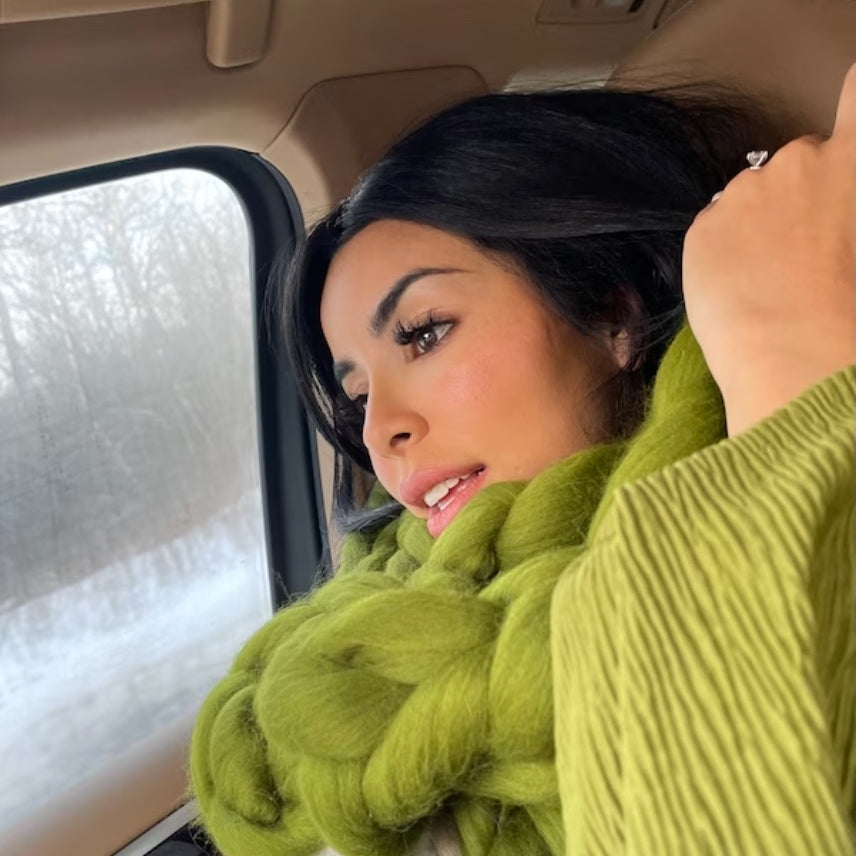 lady sitting in a car and wearing a green chunky knit scarf