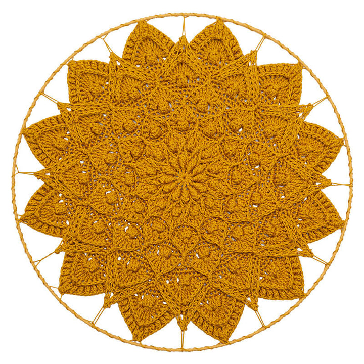 Round crochet doily with a yellowish-brown color on a white background