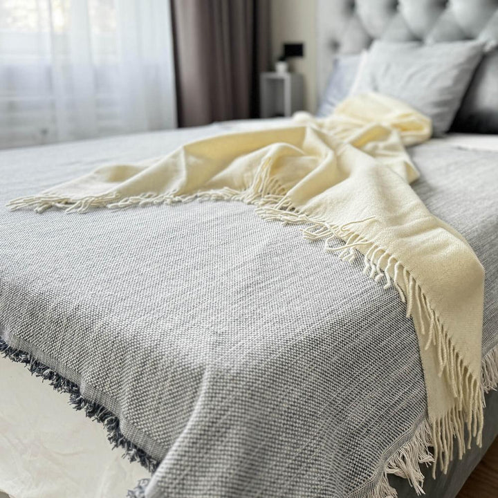 off white woven merino wool throw draped over bed in bedroom