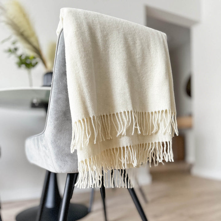 off white woven merino wool throw folded on the back of the chair