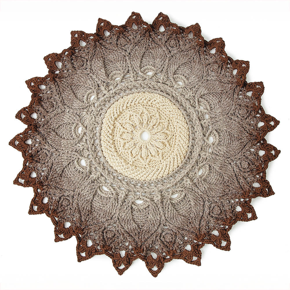 Round crochet doily with brown and beige colors on a white background