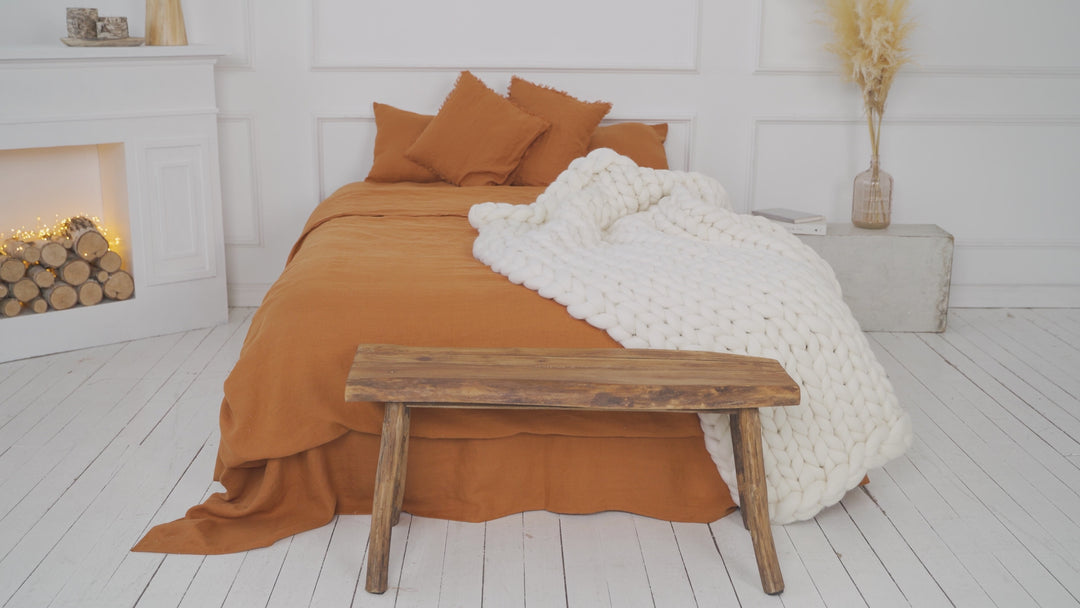 girl is showing a white chunky merino wool blanket in white on the bed