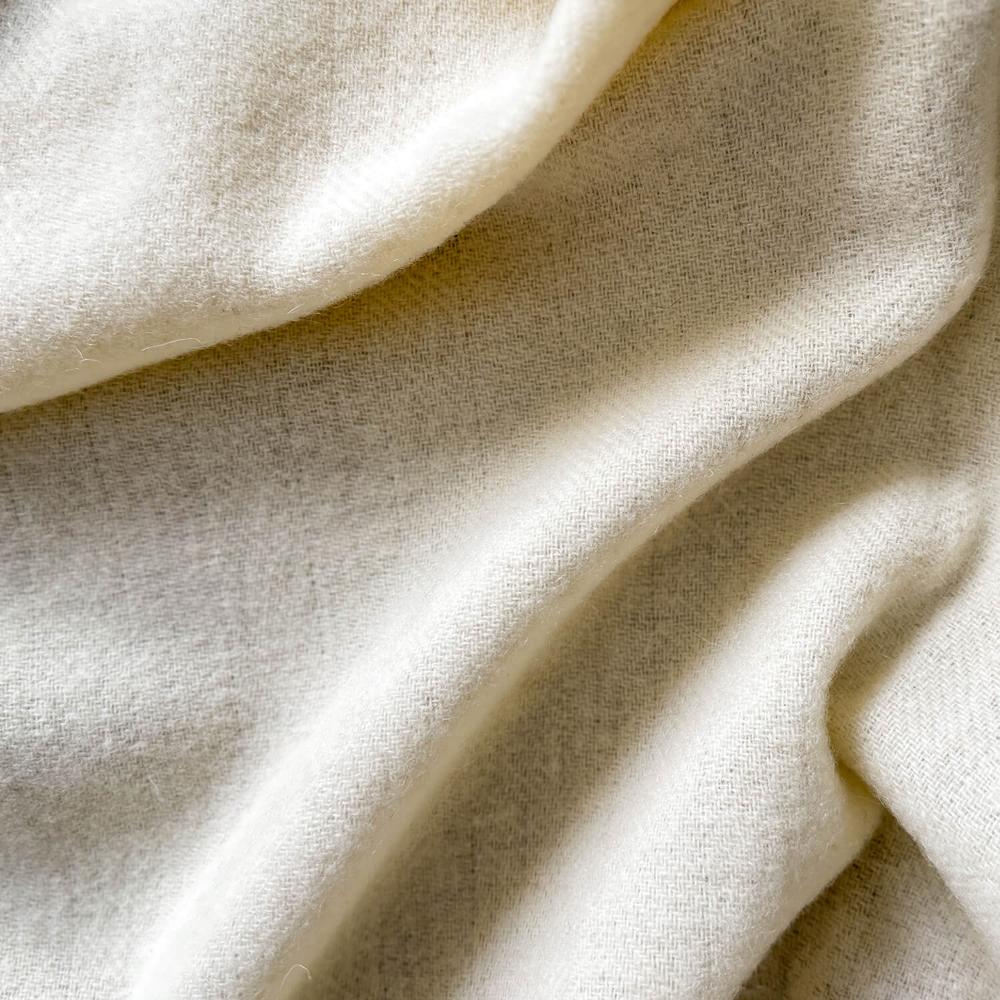 a close up picture showing texture of white merino wool blanket